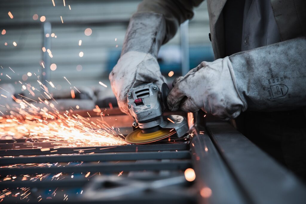 A picture of someone working in a factory. It's used to illustrate the difference between the internet of things (IoT) & the Industrial Internet of Things (IIoT).